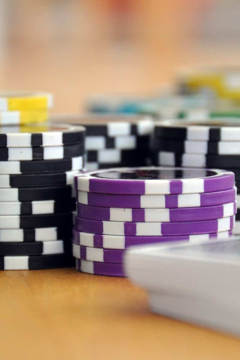 A close-up shot of stacked poker chips and playing cards on a table, perfect for casino and gambling themes.